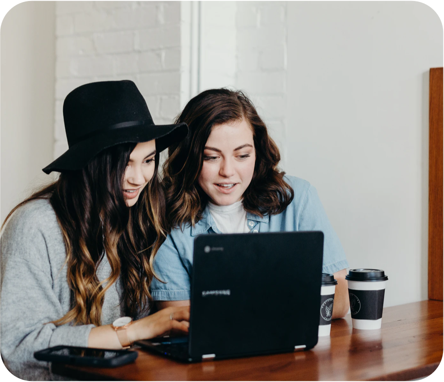 Two businesswomen looking at laptop, amazed by a unique website
